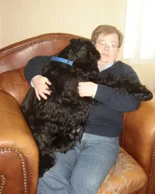 Woman embraces big fluffy dog.