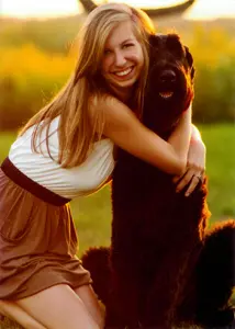 Woman hugging a large black dog