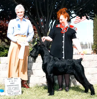 Two women showcasing a prize-winning dog