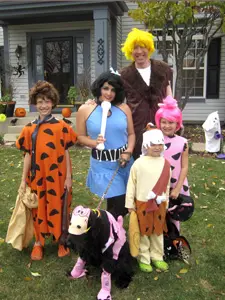 Group in Flintstones costumes outside house