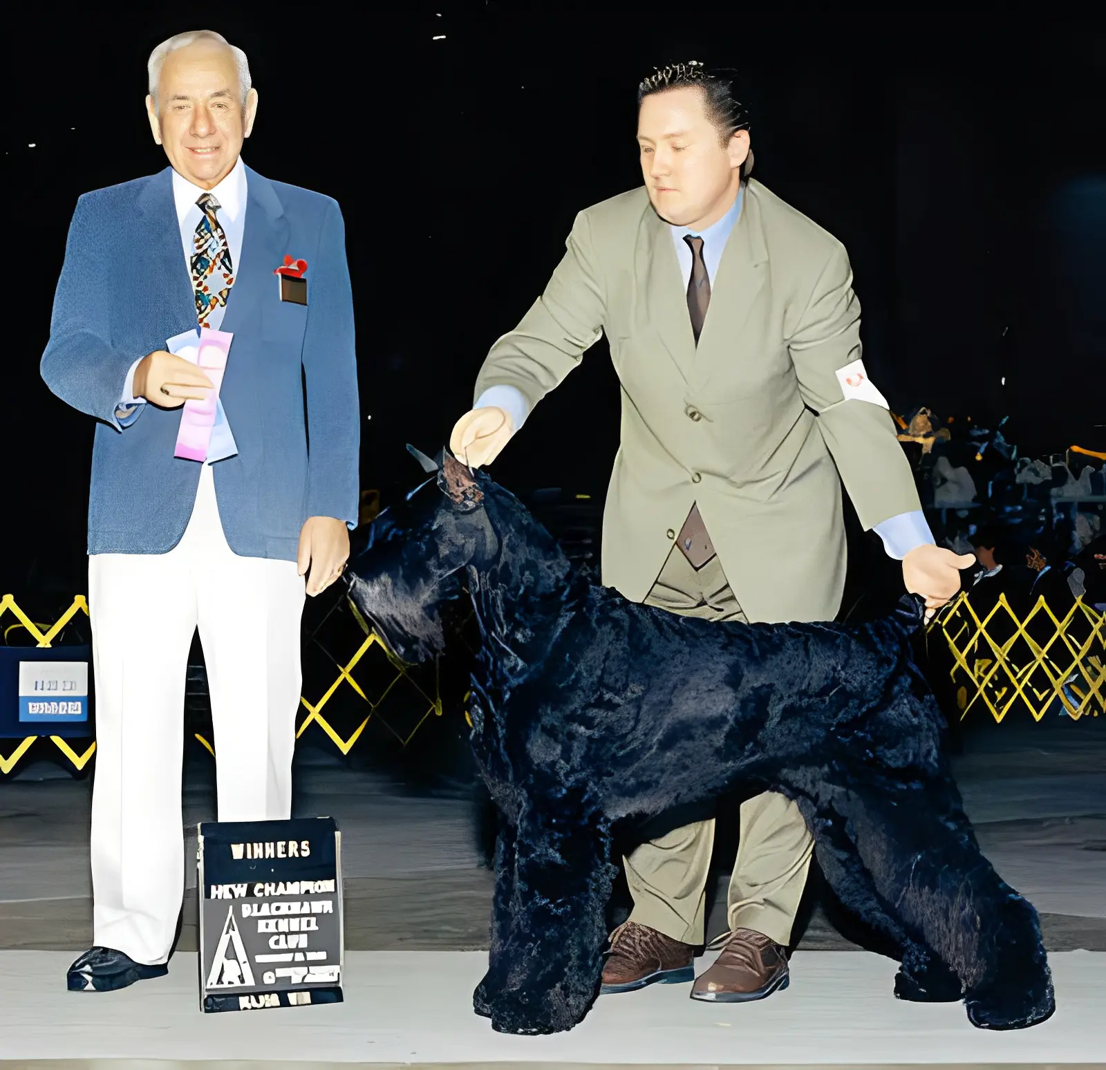 Dog show winner with handler and judge