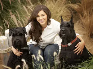 Woman sitting with black dogs outdoors